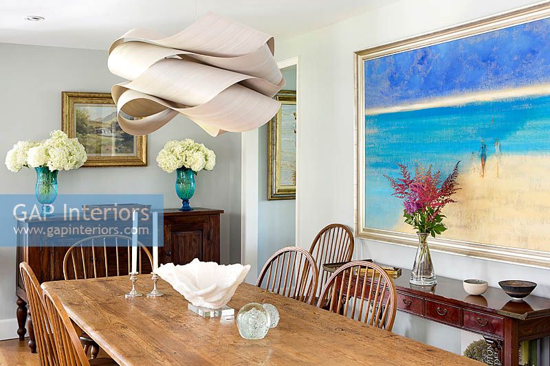 Modern pendant light above traditional dining table
