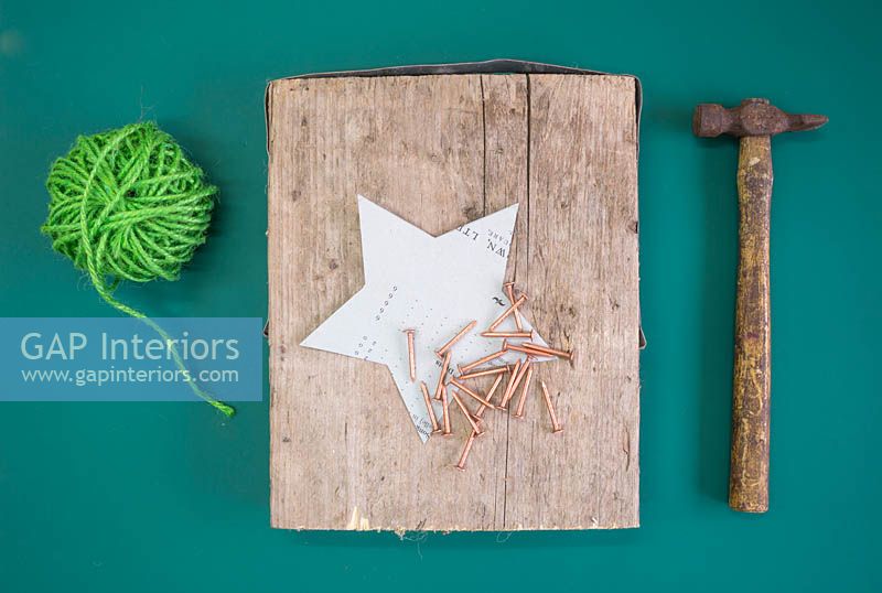 Making a christmas star decoration - Materials required are green wool, hammer, copper nails, star template and a square section of wood