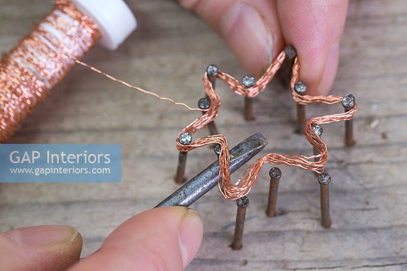 Making copper wire star decorations - Use a screwdriver or similar object to help remove the star from the nails