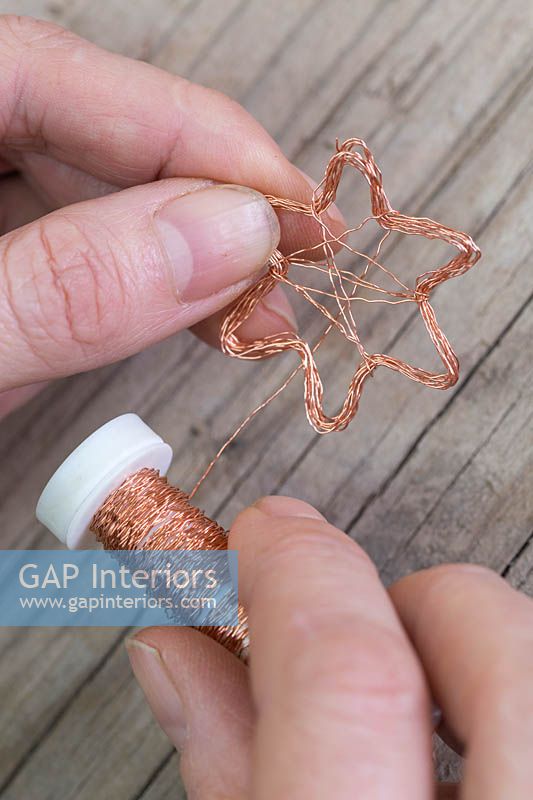 Making copper wire star decorations - Wrap additional copper wire across the inner corners of the star to create a second star 