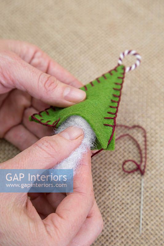 Making stitched felt christmas decorations - Insert the wool stuffing into the felt