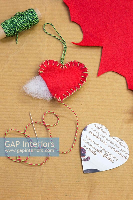 Making christmas decorations - Materials required are a heart template, needle, thread, wool and felt