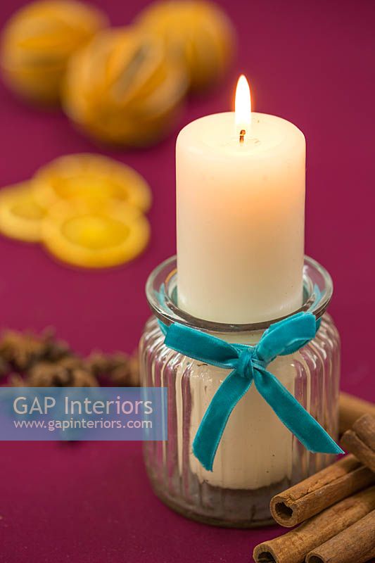 Candle in a glass jar with a felt ribbon, accompanied with Christmas themed items 