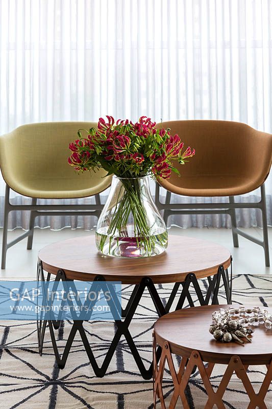 Vase of tropical flowers on circular coffee table