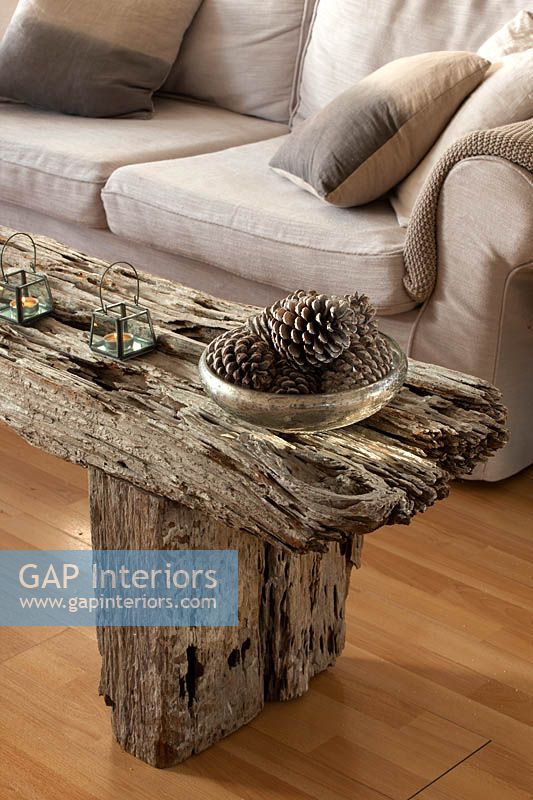 Wooden table with fir cones in silver bowl