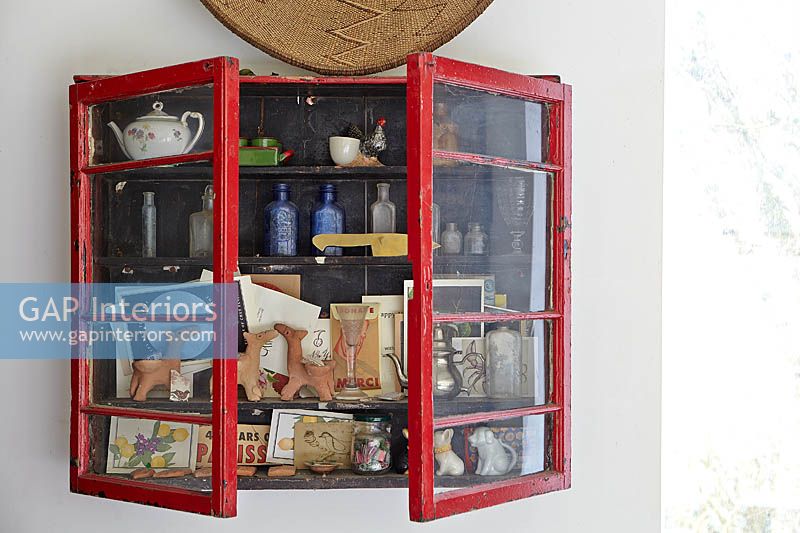 Ornaments and collectibles in red cabinet