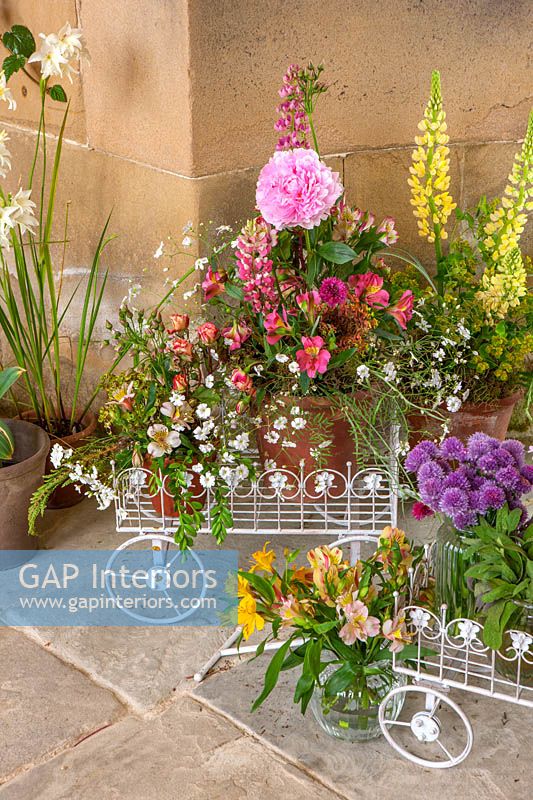 Display of flowers including Lupins and Alstroemeria in mini wheelbarrows