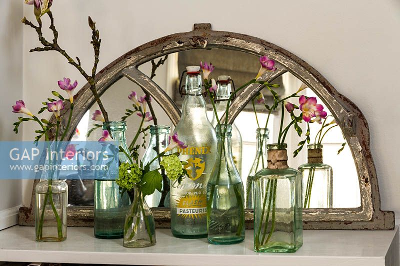 Freesia flowers in vintage bottles