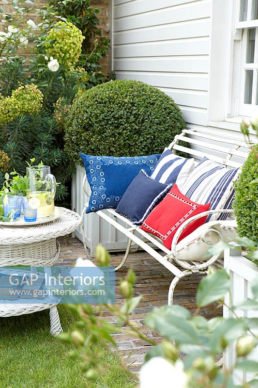 Colourful cushions on garden bench