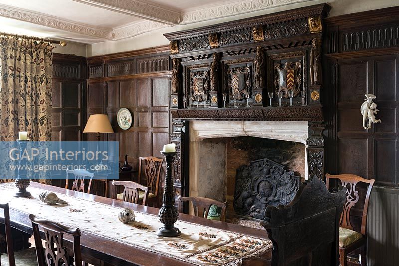 Dining room with oak panelling and ornate fireplace - Cothay Manor