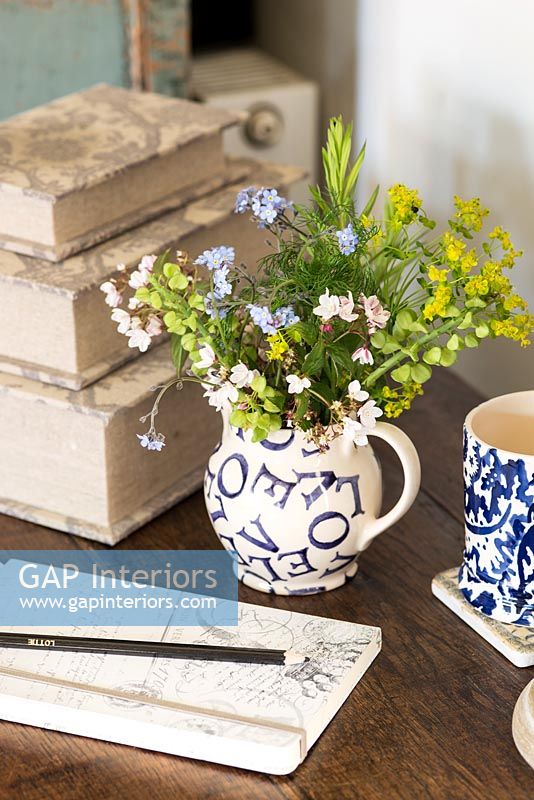 Bunch of Alchemilla and Forget-me-not flowers in patterned jug