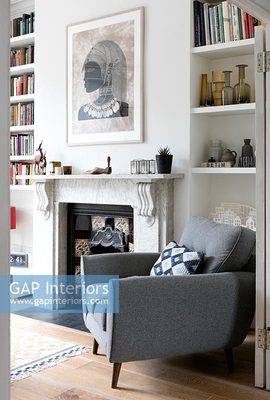 Grey armchair by period fireplace