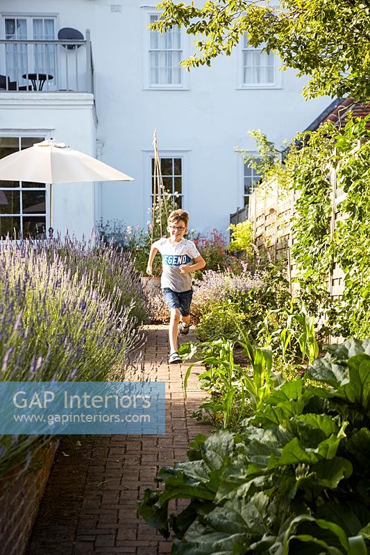 Boy running down garden path