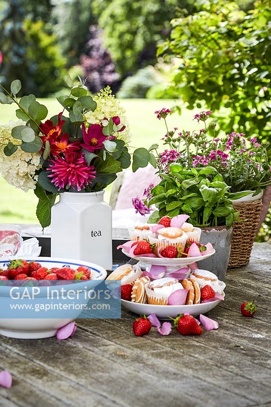 Desserts and flowers on garden table