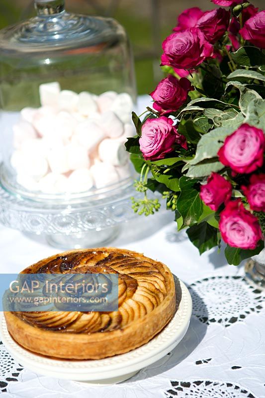 Apple tart on a table with floral arrangement