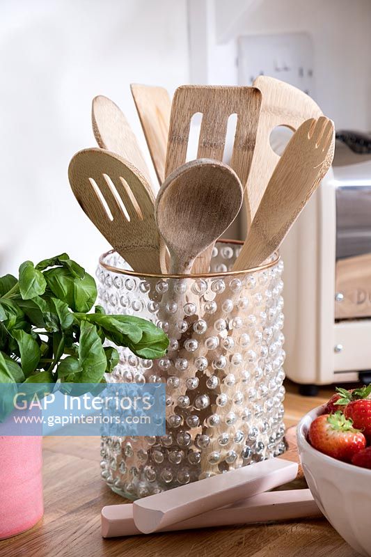 Kitchen utensils in a glass pot