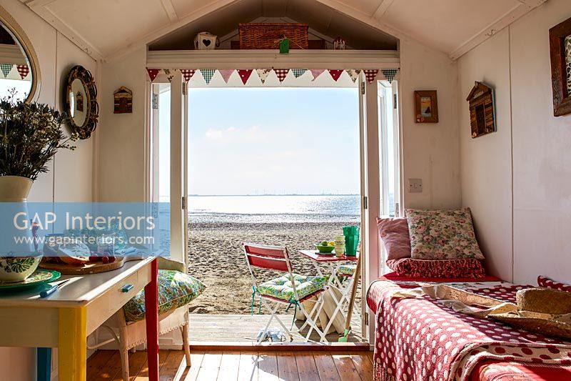 Interior of beach hut with view out to beach and sea