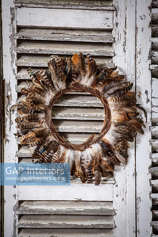 Detail of decorative feather wreath on wooden shutters