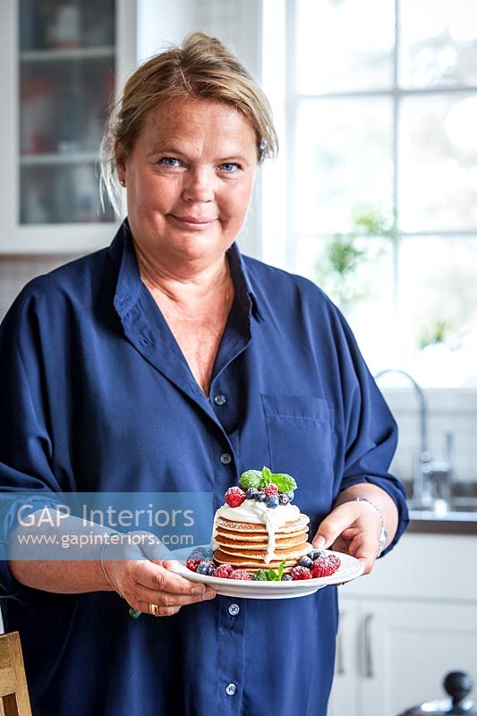 Woman holding plate of pancakes 