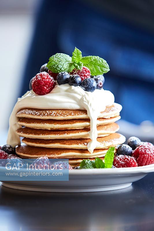 Stack of pancakes and fruit on a plate