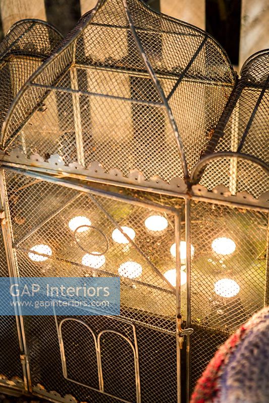 Detail of metal birdcage with tea lights