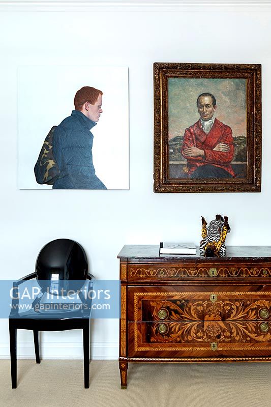 Antique cabinet with classic and modern art on wall