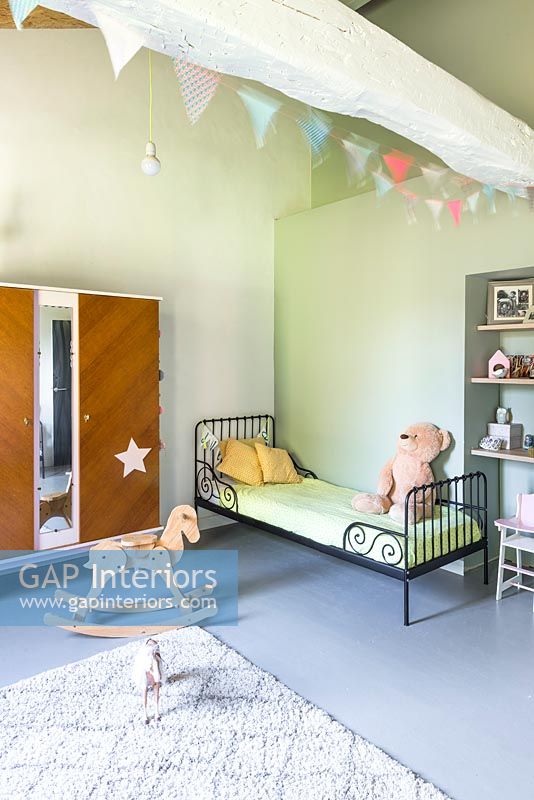Children's room with iron daybed and toys 
