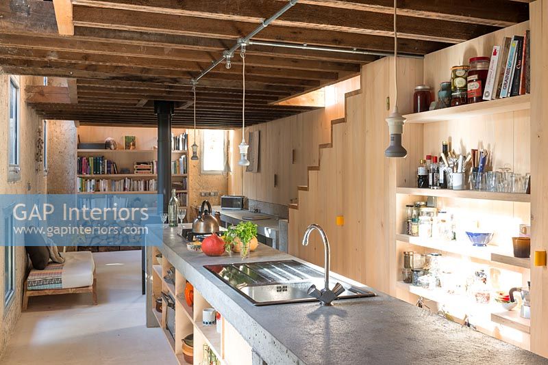 Concrete kitchen island in narrow open plan living area 