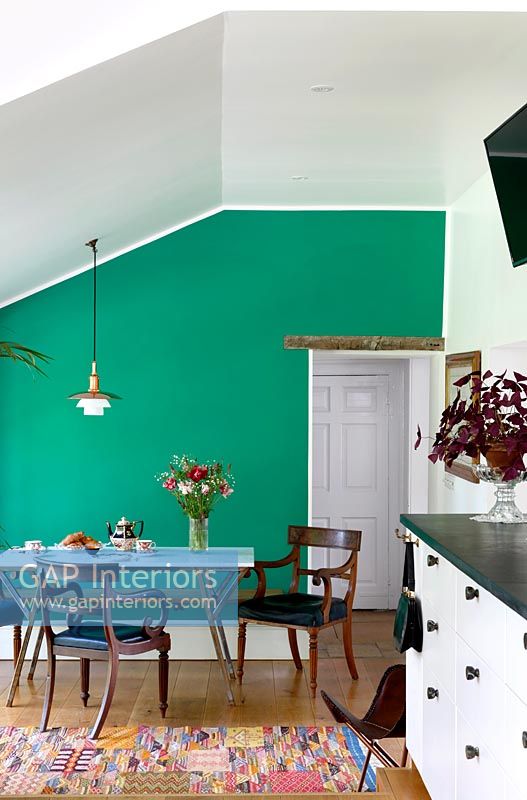 Dining area with green painted feature wall 