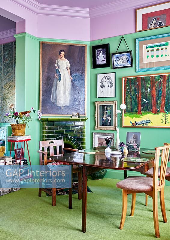 Colourful dining room with green tiled fireplace 