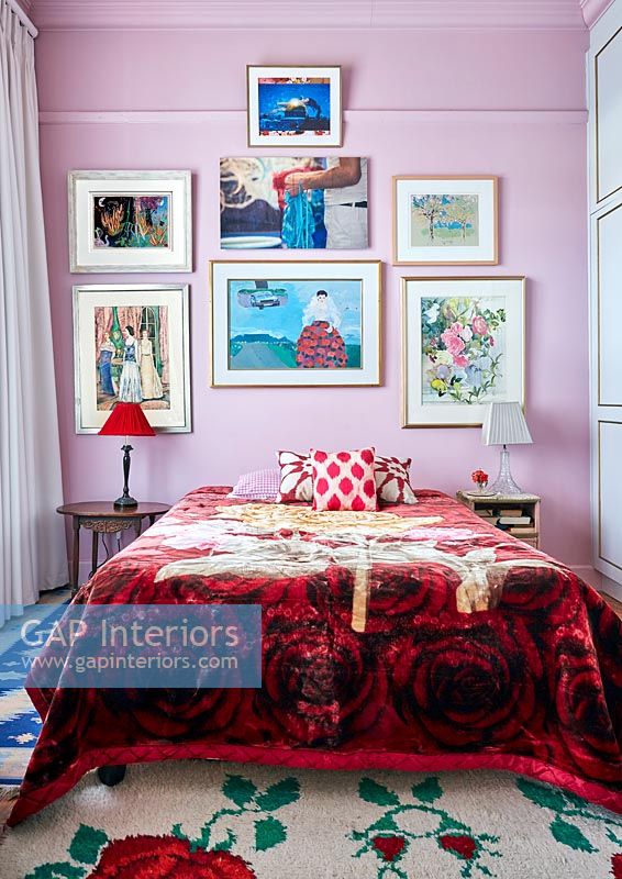 Classic colourful bedroom with display of framed paintings 