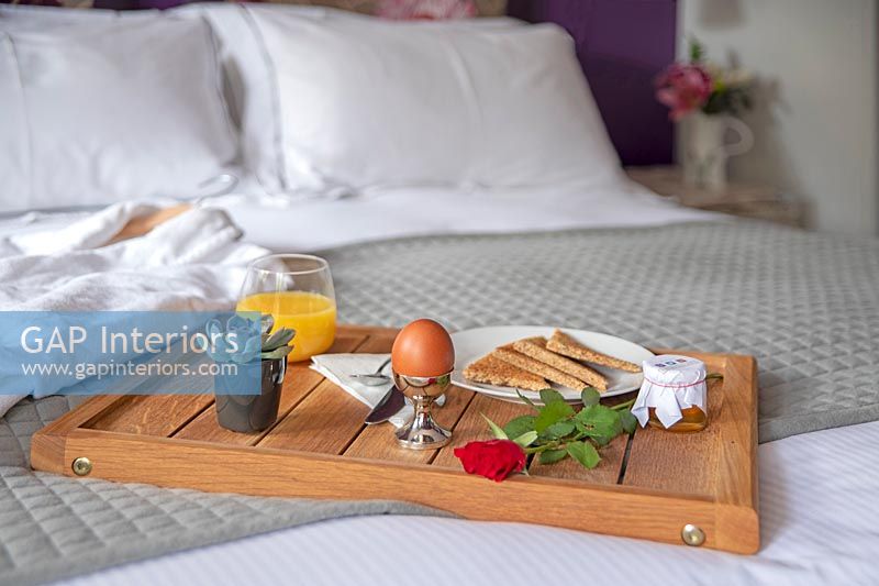 Breakfast tray on bed with bathrobe
