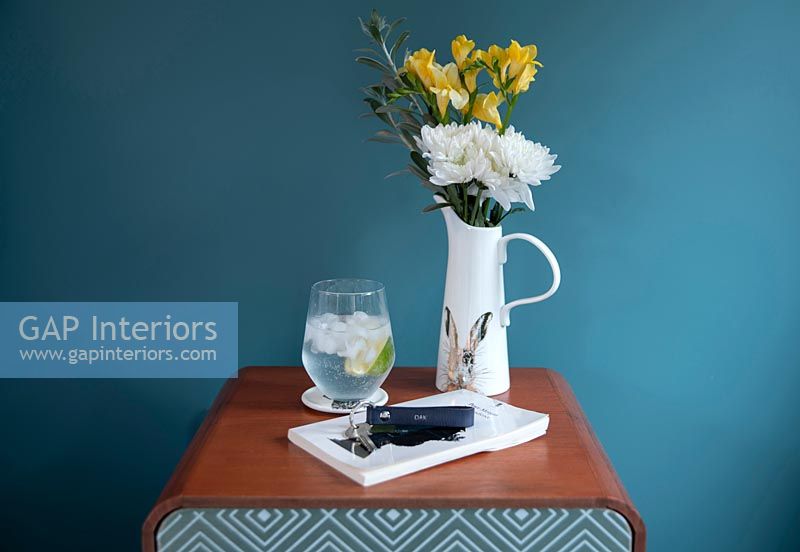 Bedside table with drink and vase
