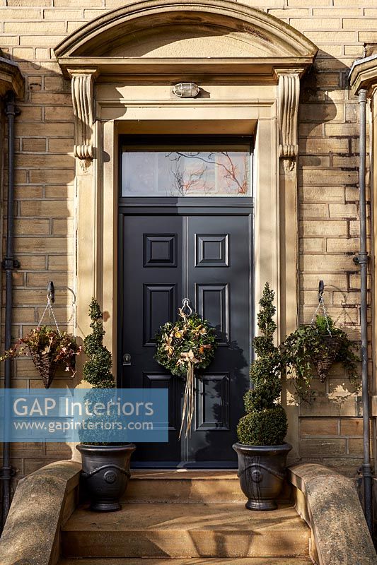 Exterior of large country house front door with Christmas wreath 