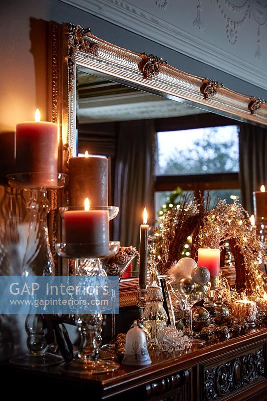 Candles and Christmas decorations on mantelpiece 