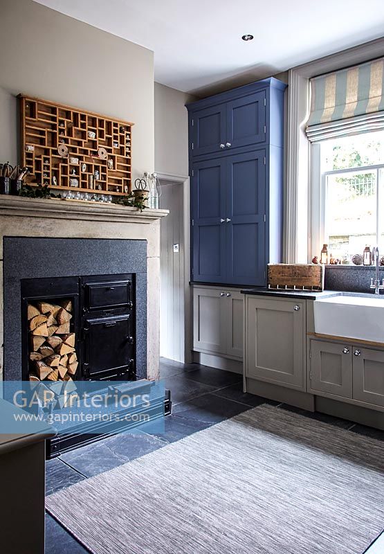 Wood burner and log store in modern country kitchen