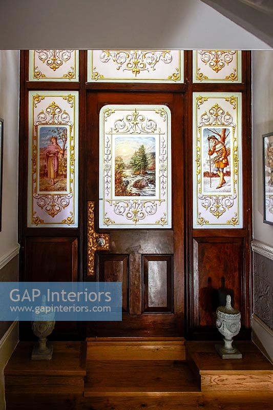 Ornate stained glass in classic wooden door and surrounding windows