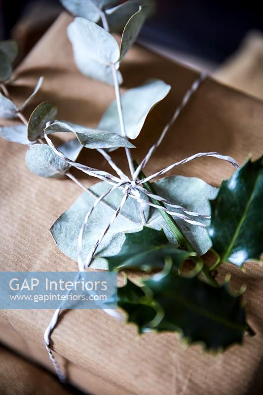 Gifts wrapped in brown paper with decorative foliage