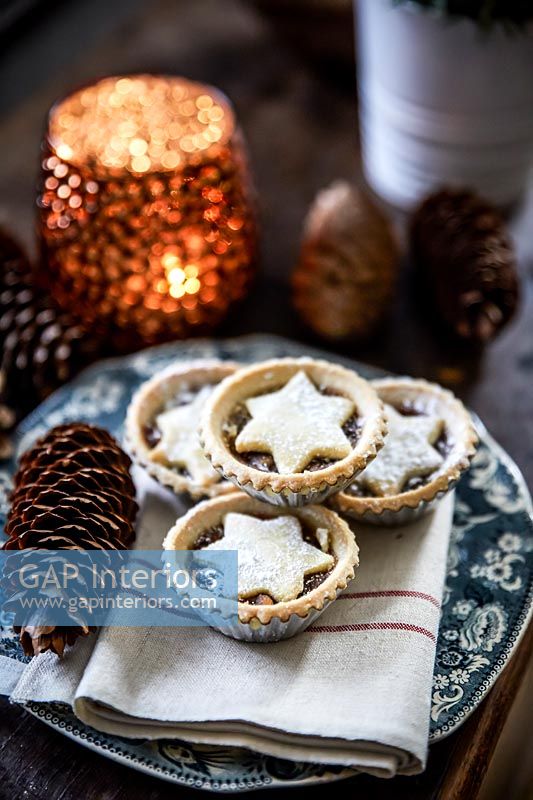 Mince pies on plate with candle 
