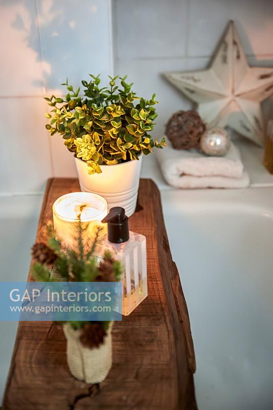Rustic wood used as bath tray with candles and plants  