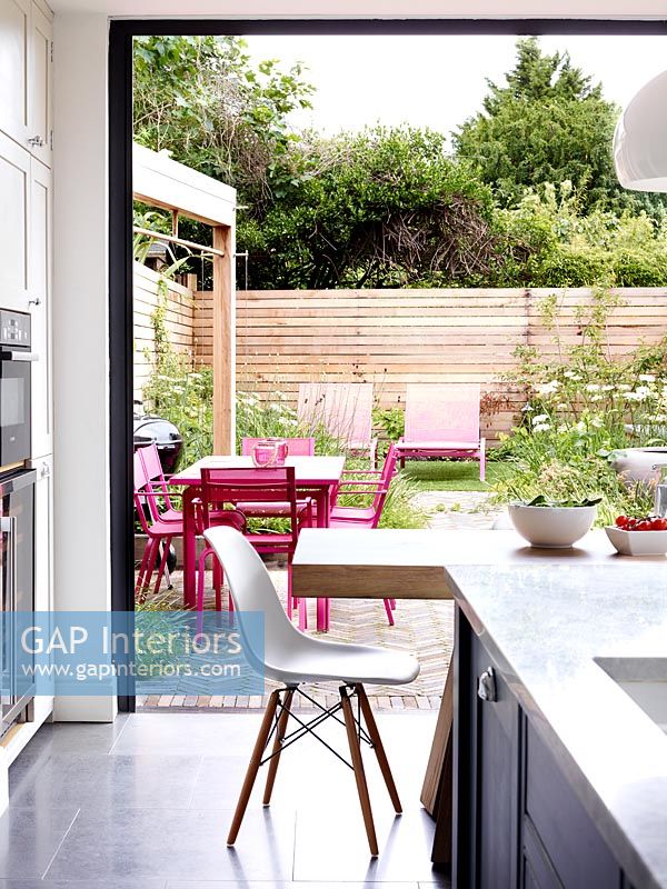 View to garden through open patio doors in modern kitchen