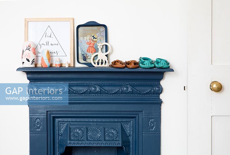Baby booties on painted iron fireplace mantelpiece 