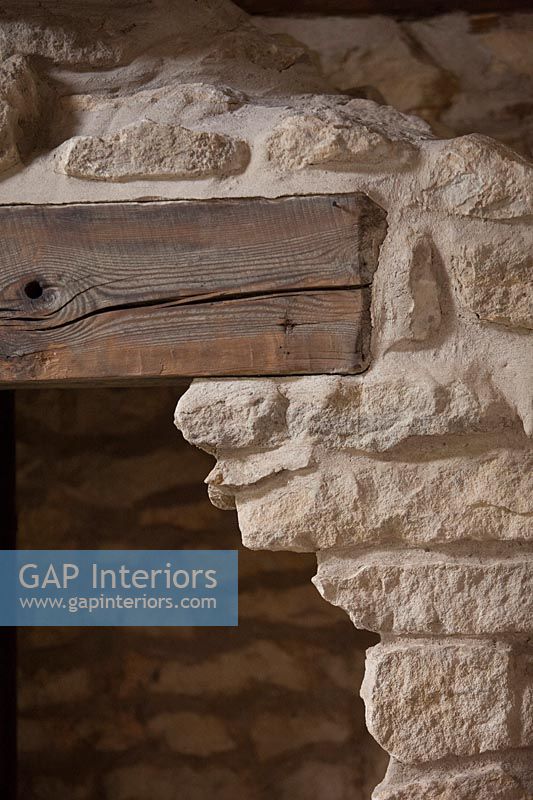Exposed stone wall and beams over door
