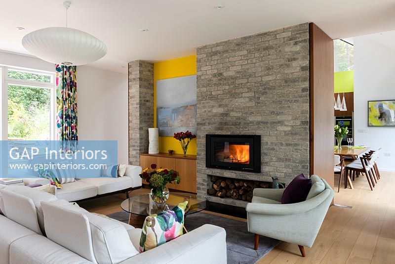 Lit fire in contemporary living room with view through to dining table 