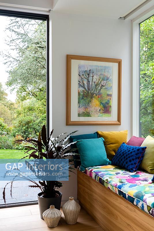 Colourful window seat and framed painting 