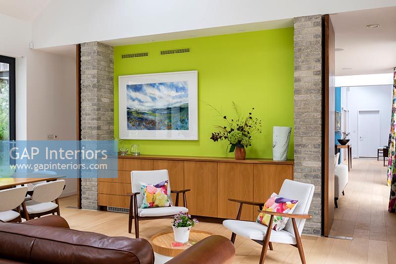 Lime green feature wall in contemporary dining room with vintage furniture 