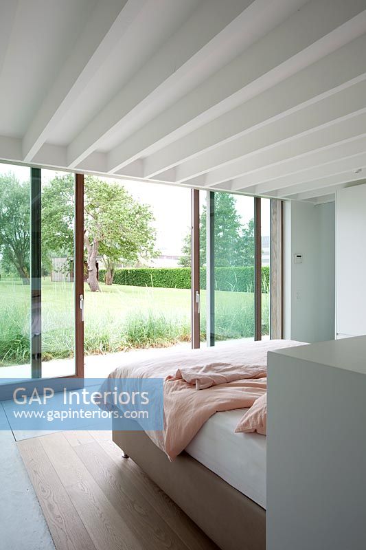 Contemporary minimal bedroom with sliding doors to garden 
