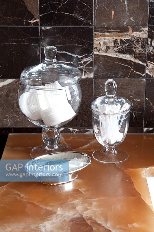 Glassware with accessories on marble bathroom sink 