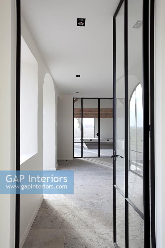 View down contemporary corridor through glass internal doors 