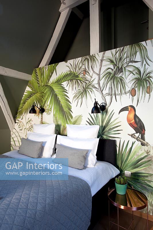 Painted tropical scene as back drop to bed in modern bedroom 